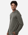 A man wearing a grey hooded long-sleeve performance t-shirt. The shirt features a logo on the front.