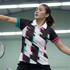 A black and white active polo shirt with pink and turquoise accents, featuring a logo. Ideal for sportswear.