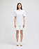 White cotton gym shorts displayed on a model, featuring a logo, paired with a matching white top and white sneakers.