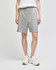 Grey cotton gym shorts with an elastic waistband, worn by a person standing in white shoes. Features a logo.