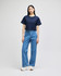 A cropped short sleeve t-shirt in navy blue worn with high-waisted denim jeans. Features a logo detail.