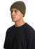 A beanie in olive green displayed on a model wearing a black t-shirt, featuring ribbed texture.