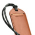 A tan leather luggage tag with a dark string, featuring a slot for identification.