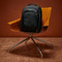 A black Samsonite Xenon 3.0 Backpack rests on a wooden chair with a chrome base.