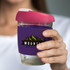 A drink bottle featuring a transparent borosilicate design, with a pink lid and a purple silicone sleeve.