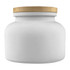 A white candle jar with a textured gold lid, featuring a simple and elegant design.