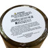 A floral candle in a glass container with a warning label on the base, featuring earthy tones and a subtle design.