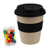 A bamboo cup with a black lid and band, accompanied by a packet of multicoloured jelly beans.