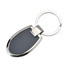 A key ring with a sleek silver and black design, featuring a large oval-shaped body and a metal keyring attachment.