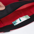A red tote bag with a black trim, featuring an interior pocket and a decorative card inside.