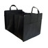 A black non-woven cargo organiser with multiple compartments and two handles for carrying.