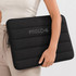 A black neoprene laptop sleeve with a padded design, featuring a subtle logo on the front.
