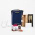 A navy gift set featuring glasses, a wooden board, a knife, canned drinks, and festive treats. Includes a branded bag.