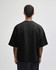 A black oversized boxy top made from French terry fabric, featuring a simple design and a logo on the back.