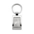 A silver keytag with a rectangular frame and a circular keyring, featuring a branded logo.