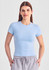 A light blue women's baby tee, featuring short sleeves and a fitted design, worn with grey joggers.
