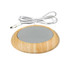 A wooden USB cup warmer with a smooth grey surface and a white power cord. It features a minimalist design.