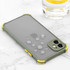 A rugged green iPhone case with yellow accents, featuring water droplets on its surface, placed on a marble countertop.