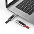 A silver and black Churchill flash drive is plugged into a laptop, with a red one next to it.