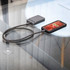 A black magnetic wireless power bank connected to a phone on a glass table. The power bank has a sleek design.