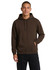 A light grey men's hoodie with a kangaroo pocket, worn by a young man standing casually.