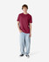 A unisex heavyweight cotton t-shirt in maroon, worn with light blue baggy jeans and black sneakers, featuring a logo.