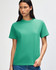 A green heavyweight cotton unisex T-shirt is displayed on a model with curly hair, featuring a simple design and a logo.