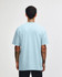 A light blue heavyweight cotton unisex T-shirt displayed from the back, featuring a casual fit.
