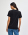 A black heavyweight cotton unisex T-shirt displayed on a model from the back, featuring a simple design and loose fit.