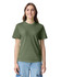 A woman wears an olive green adult heavyweight t-shirt with a casual fit. The shirt features a logo on the front.