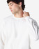 A white Gildan Heavy Blend adult crewneck sweatshirt on a model. The sweatshirt features long sleeves and a relaxed fit.