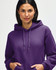 A purple hooded sweatshirt is being worn by a young man, who is pulling the hood over his head.