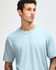 A unisex fine jersey short sleeve t-shirt in light blue, worn by a model with dark jeans and sneakers.