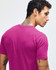 A pink short sleeve T-shirt featuring a simple design and a small logo on the back.