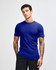 A blue unisex short sleeve t-shirt displayed on a model with curly hair. Features a logo on the shirt.