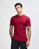 A maroon unisex fine jersey short sleeve t-shirt displayed on a model. The shirt features a logo.