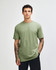 A plain green unisex CVC short sleeve T-shirt displayed on a model, featuring a subtle logo.