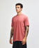 A unisex short sleeve T-shirt in a muted terracotta colour, featuring a minimalist design and a logo.