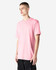 A pink unisex CVC short sleeve T-shirt displayed on a model. The shirt has a simple design and a logo.