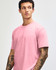 A unisex short sleeve T-shirt in pink, featuring a simple design and a logo.
