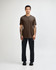 A unisex short sleeve T-shirt in brown, displayed by a model, paired with dark cargo pants and footwear.
