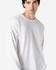 A white long sleeve t-shirt on a model, showcasing a classic fit and simple design. The shirt features a logo.