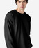 A model wearing a black long sleeve t-shirt made of ultra cotton, featuring a simple design and relaxed fit.