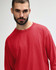 A red long sleeve t-shirt with a relaxed fit, featuring a logo on the front.