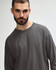 A long sleeve adult t-shirt in grey, featuring a simple design and a logo on the shirt.