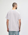 A man wearing a light grey Gildan Heavy Cotton Adult T-Shirt, viewed from the back. The shirt has a logo.
