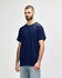 A navy adult T-shirt displayed on a model, featuring a basic design and a logo on the sleeve.
