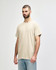 A light beige adult t-shirt in a casual style, featuring a crew neck and short sleeves. It has a branding logo on the tag.