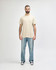A light beige Gildan Heavy Cotton Adult T-Shirt worn by a male model, paired with black jeans and sneakers.