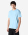 A light blue Gildan Heavy Cotton adult t-shirt is displayed on a model. It features short sleeves and a simple design.